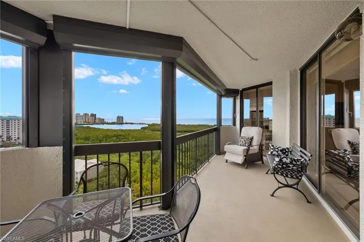 Sunroom featuring a balcony, a water view, and plenty of natural light