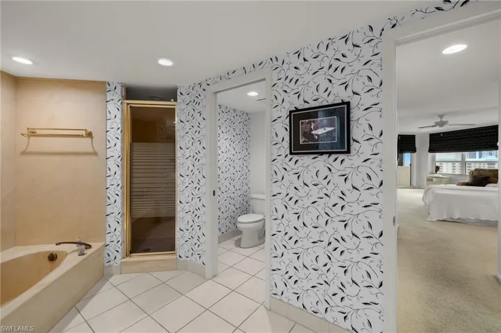 Ensuite bathroom with a garden tub, a ceiling fan, light tile patterned floors, recessed lighting, and a stall shower