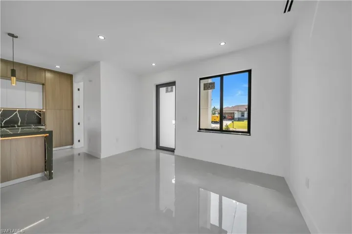Unfurnished living room with recessed lighting and baseboards
