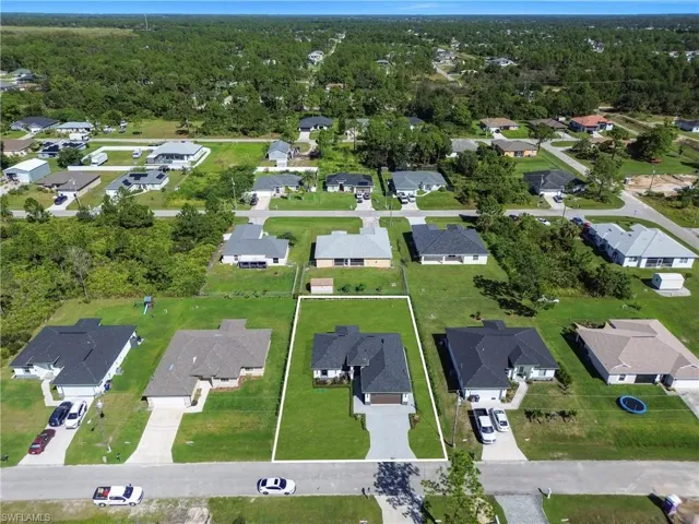 Aerial view of property and surrounding area with nearby suburban area and property parcel outlined