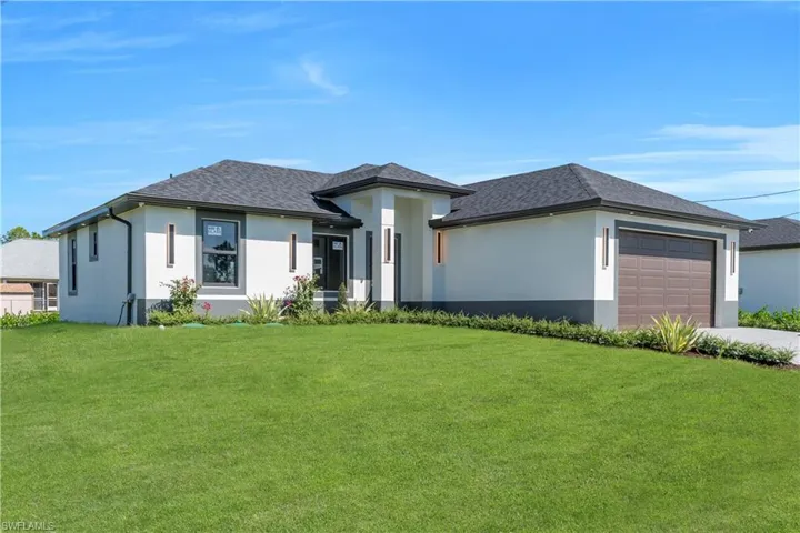 Prairie-style home with stucco siding, a front yard, and roof with shingles