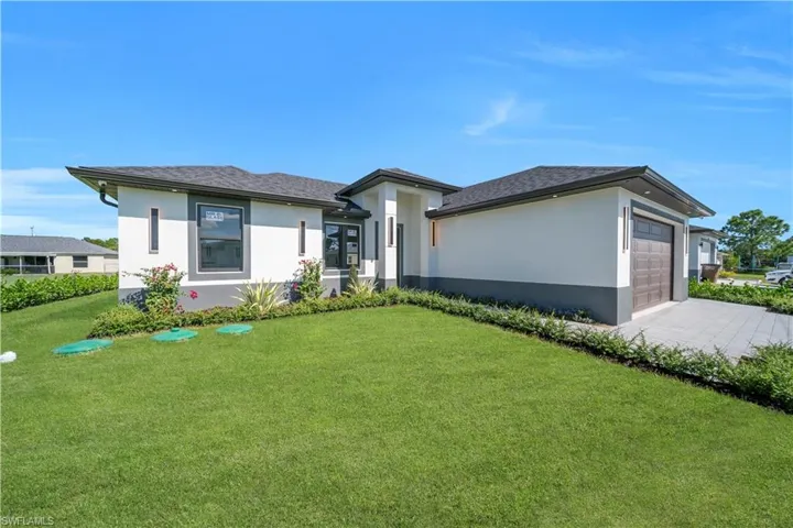 Prairie-style house featuring a front yard, stucco siding, an attached garage, and roof with shingles