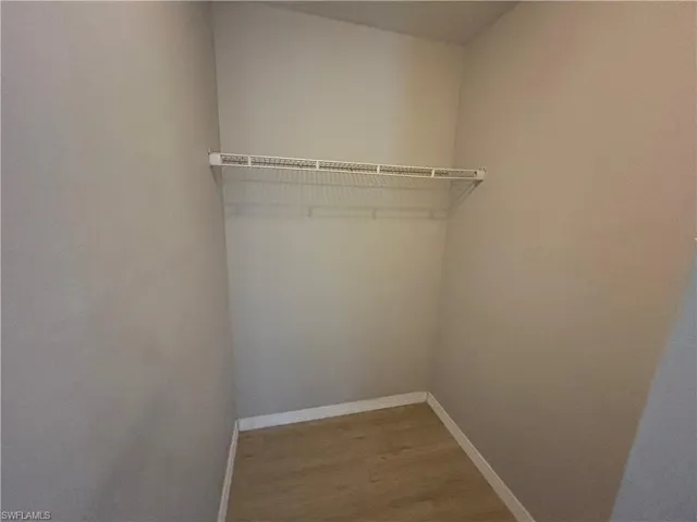 Walk in closet with light wood finished floors