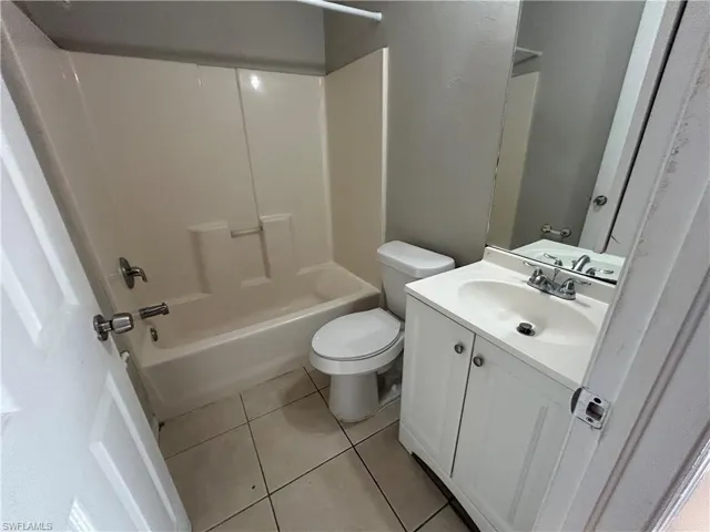 Full bath featuring light tile patterned flooring, tub / shower combination, and vanity