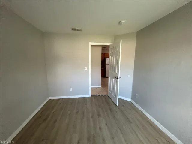 Unfurnished room with baseboards and wood finished floors