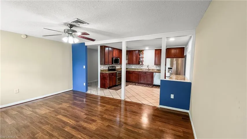 Kitchen featuring sink, stainless steel appliances, light hardwood / wood-style floors, and a textured ceiling