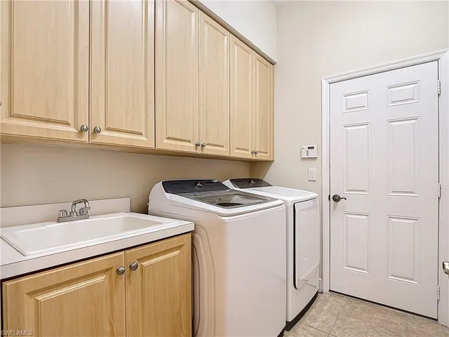 Main Floor Laundry with Tub and Cabinetry