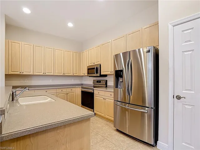Kitchen with stainless steel appliances, recessed lighting, light wood finish cabinets, and light tile floors