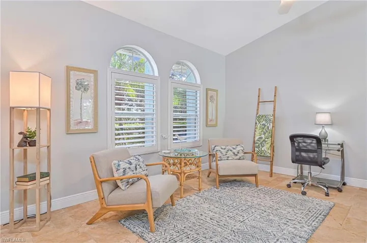 Living area featuring vaulted ceiling and light stone finish floors