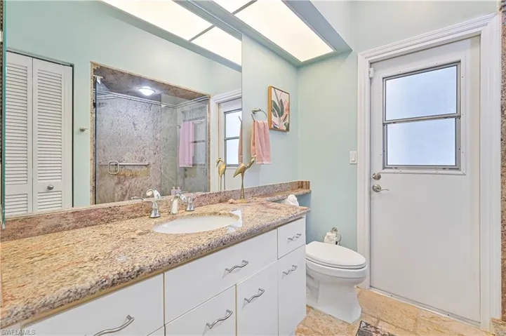 Full bathroom featuring a closet, a shower stall, and vanity