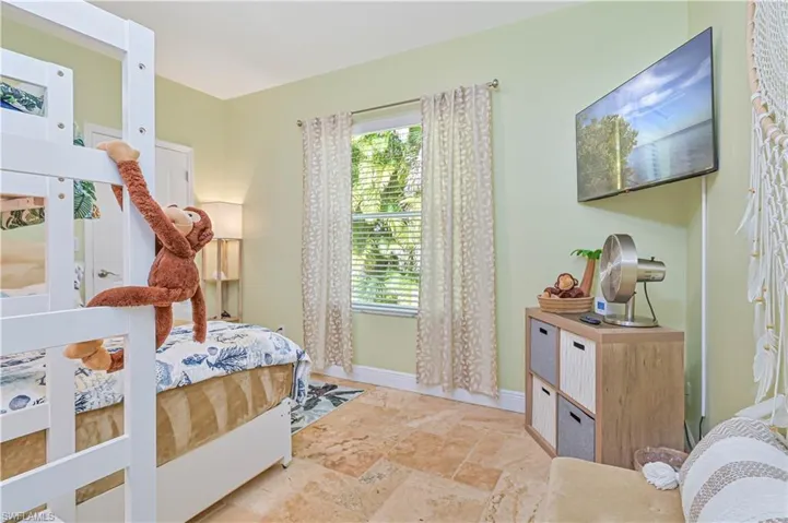 Bedroom featuring stone tile floors and baseboards