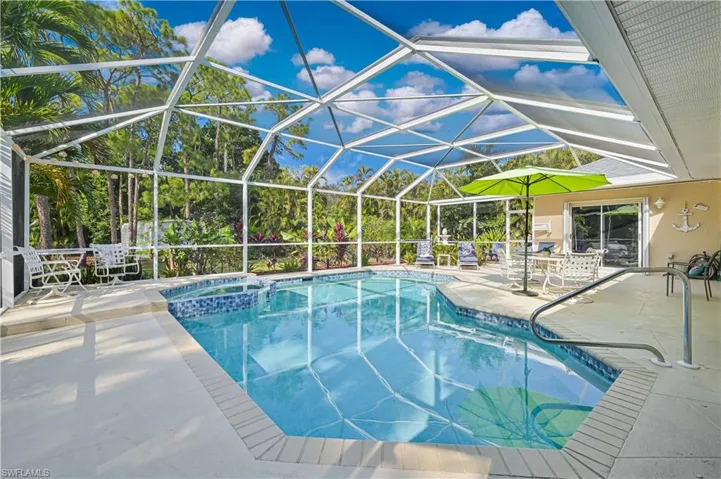 Relaxing pool / spa featuring a patio, a sunroom, and glass enclosure
