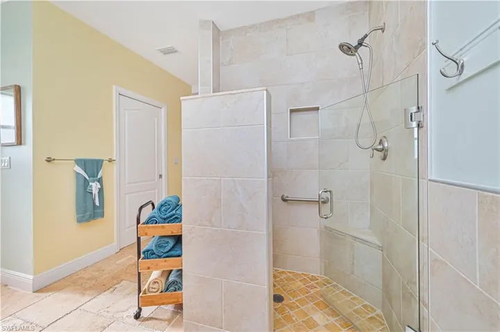 Full bath featuring a stall shower and stone tile flooring