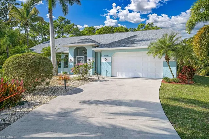 Ranch-style house with an attached garage, stucco siding, driveway, and roof with shingles