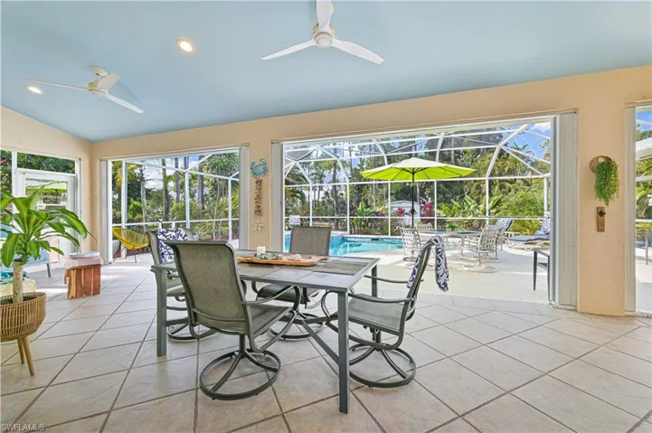 Sunroom / solarium with outdoor dining area, ceiling fan, vaulted ceiling, and a patio area