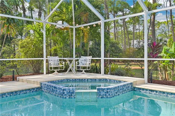 Relaxing pool / spa featuring glass enclosure and a sunroom