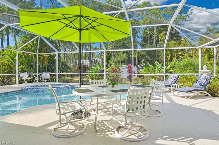 Combined pool / hot tub featuring a lanai, a sunroom, outdoor dining area, and a patio area