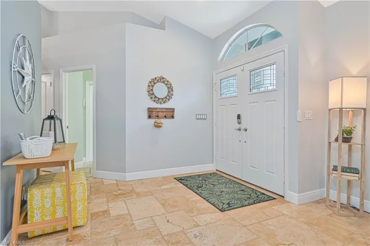 Foyer with stone tile floors and vaulted ceiling