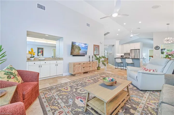 Living area featuring a chandelier, a ceiling fan, and lofted ceiling