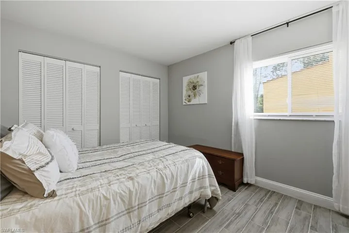 Bedroom featuring multiple closets and wood tiled floors