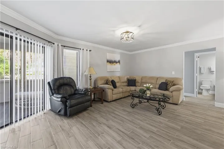 Living area with ornamental molding and wood finish floors