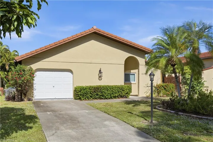 Mediterranean / spanish home with driveway, a garage, stucco siding, a front yard, and a tiled roof
