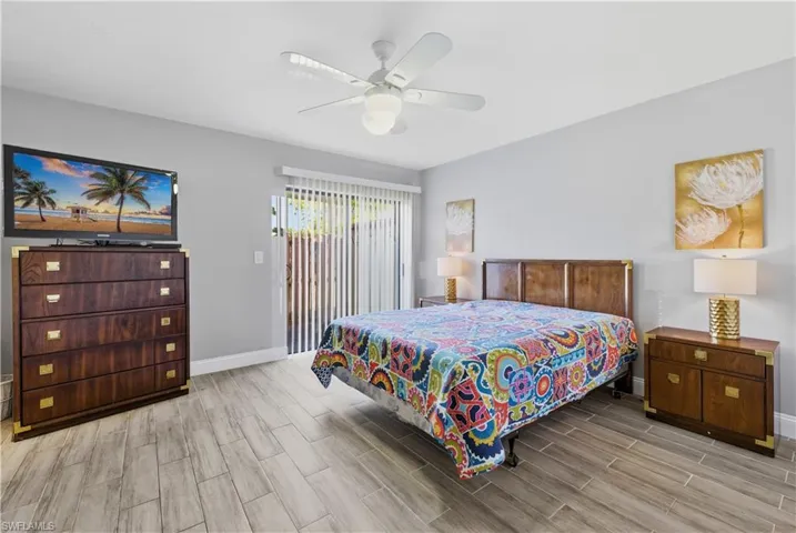 Bedroom featuring a ceiling fan, wood finish floors, and access to outside