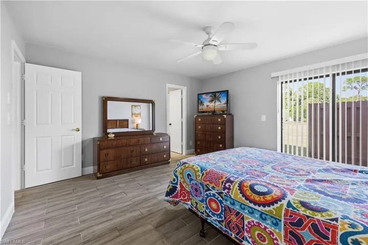 Bedroom with access to outside, wood tiled floors, and a ceiling fan
