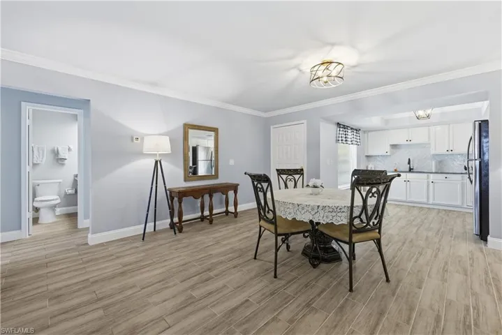 Dining room with crown molding and light wood-style floors