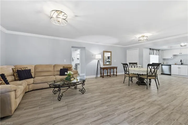 Living room with crown molding and wood finish floors