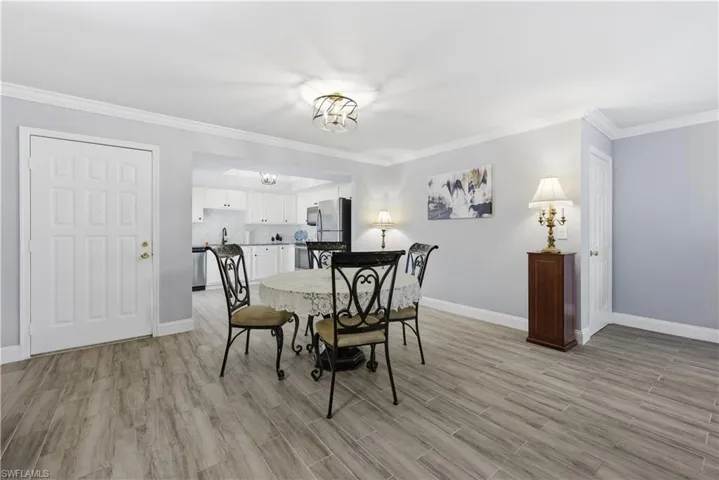 Dining space with crown molding and light wood finished floors