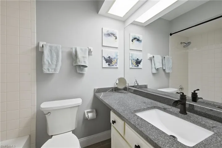 Bathroom featuring vanity, shower / washtub combination, and a skylight