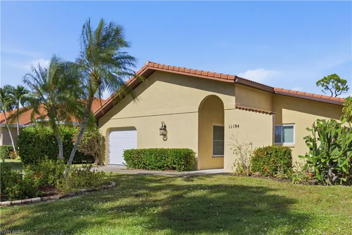 Mediterranean / spanish home featuring a garage, a front yard, stucco siding, and a tile roof