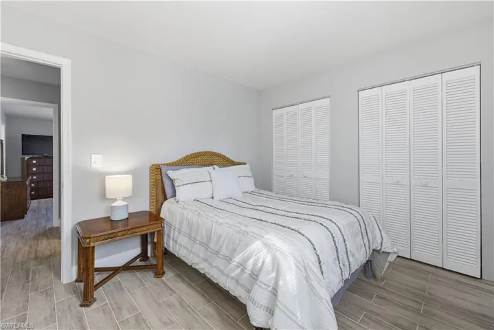 Bedroom with wood tiled floors and multiple closets
