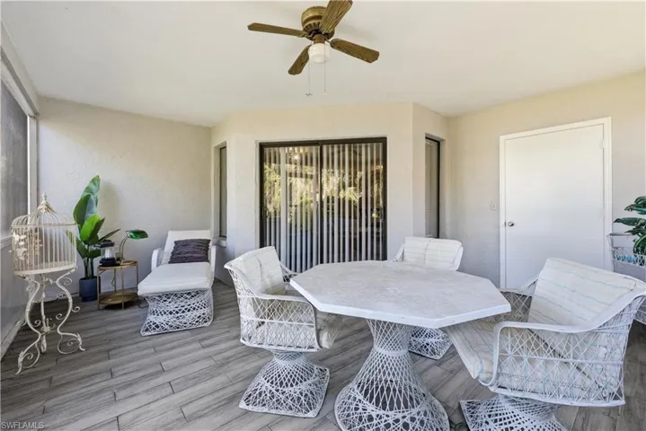 Sunroom / solarium featuring outdoor dining area and a ceiling fan
