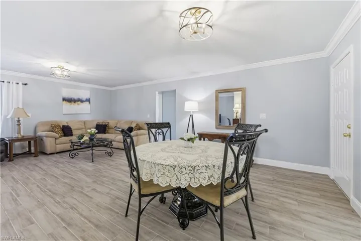 Dining space with wood tiled floors and crown molding