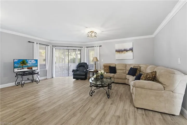 Living room with crown molding and wood tiled floors