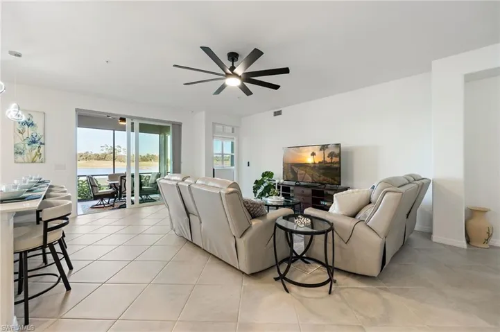 Living room with tile flooring & sliders to the screened lanai
