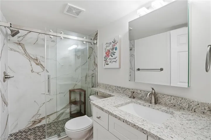 Full bath featuring vanity and a marble finish shower - Virtually Edited Image