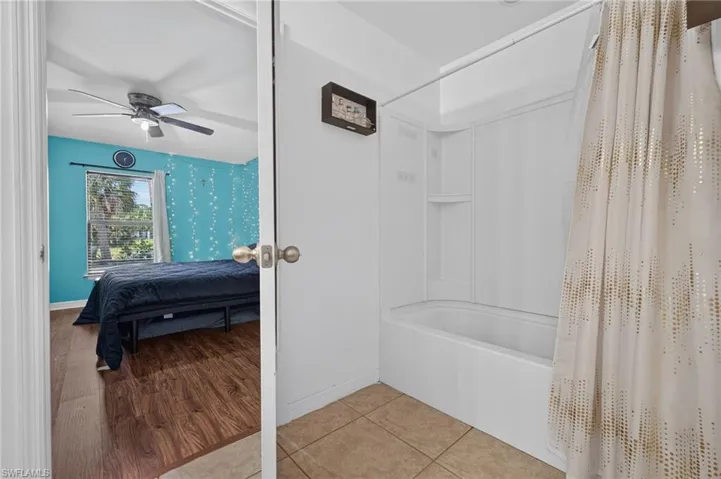 Bathroom featuring a white tub-shower combination with integrated shelving
