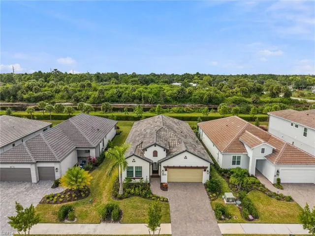 Single-story residence featuring a paver driveway, multi-toned tile roof, neutral stucco exterior, and attached two-car garage