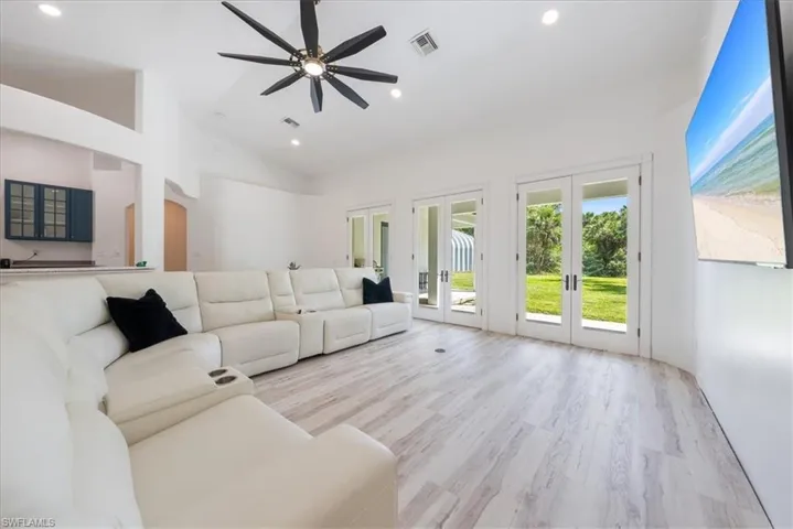 Living room featuring french doors, light wood-style flooring, high vaulted ceiling, a ceiling fan, and recessed lighting