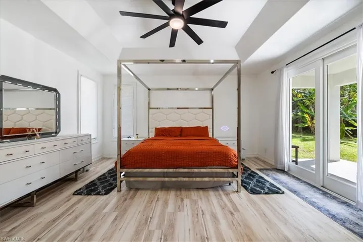 Bedroom featuring access to exterior, multiple windows, and light wood-style flooring