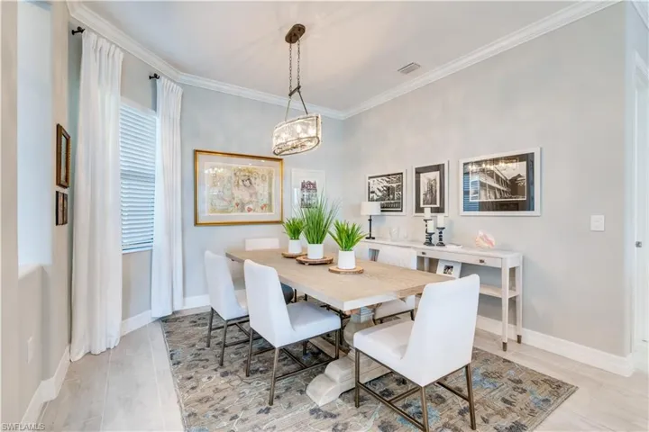 Dining room featuring an inviting chandelier, ornamental molding, and light tile flooring
