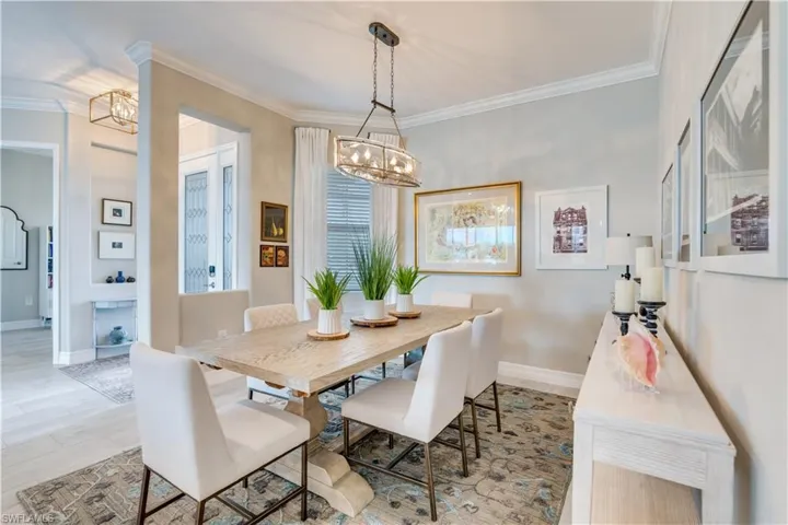 Dining room with crown molding and a notable chandelier