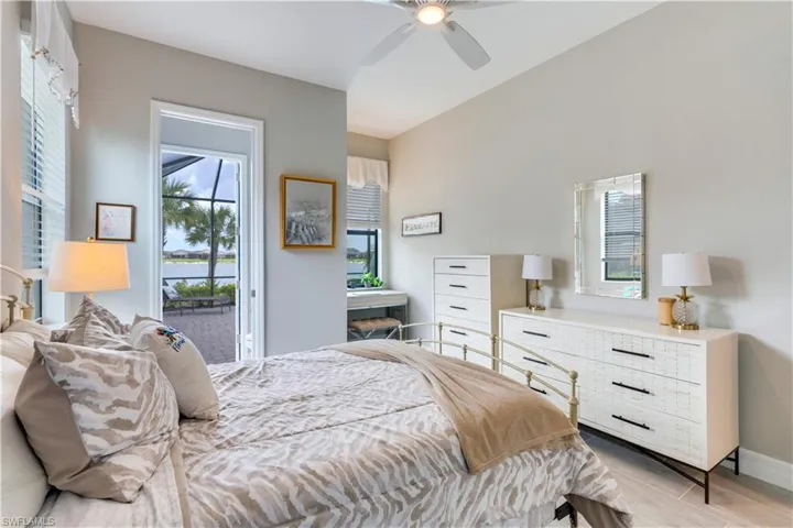 Tiled bedroom featuring access to outside, multiple windows, and ceiling fan