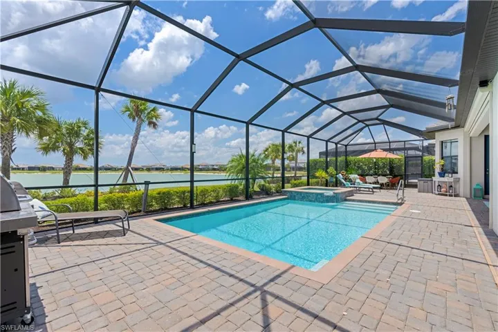 View of swimming pool featuring a patio, a lanai, and an in ground hot tub