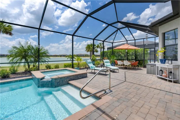 View of swimming pool with a lanai, an in ground hot tub, and a patio