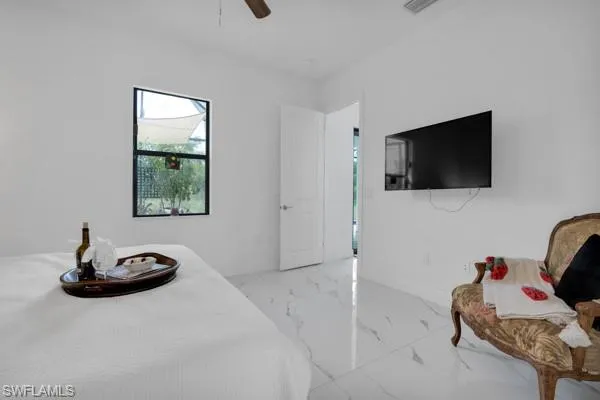 Bedroom featuring marble finish flooring and a ceiling fan