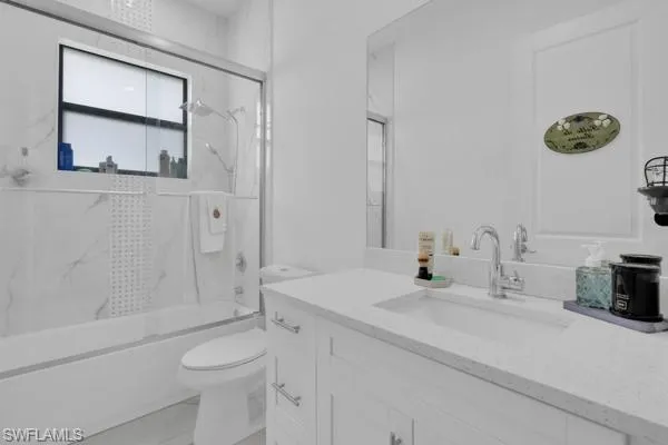 Full bath featuring enclosed tub / shower combo and vanity